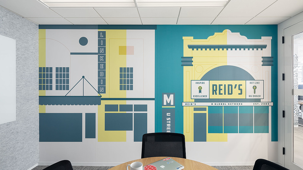 A table with a coffee cup and a wall with a cartoon.